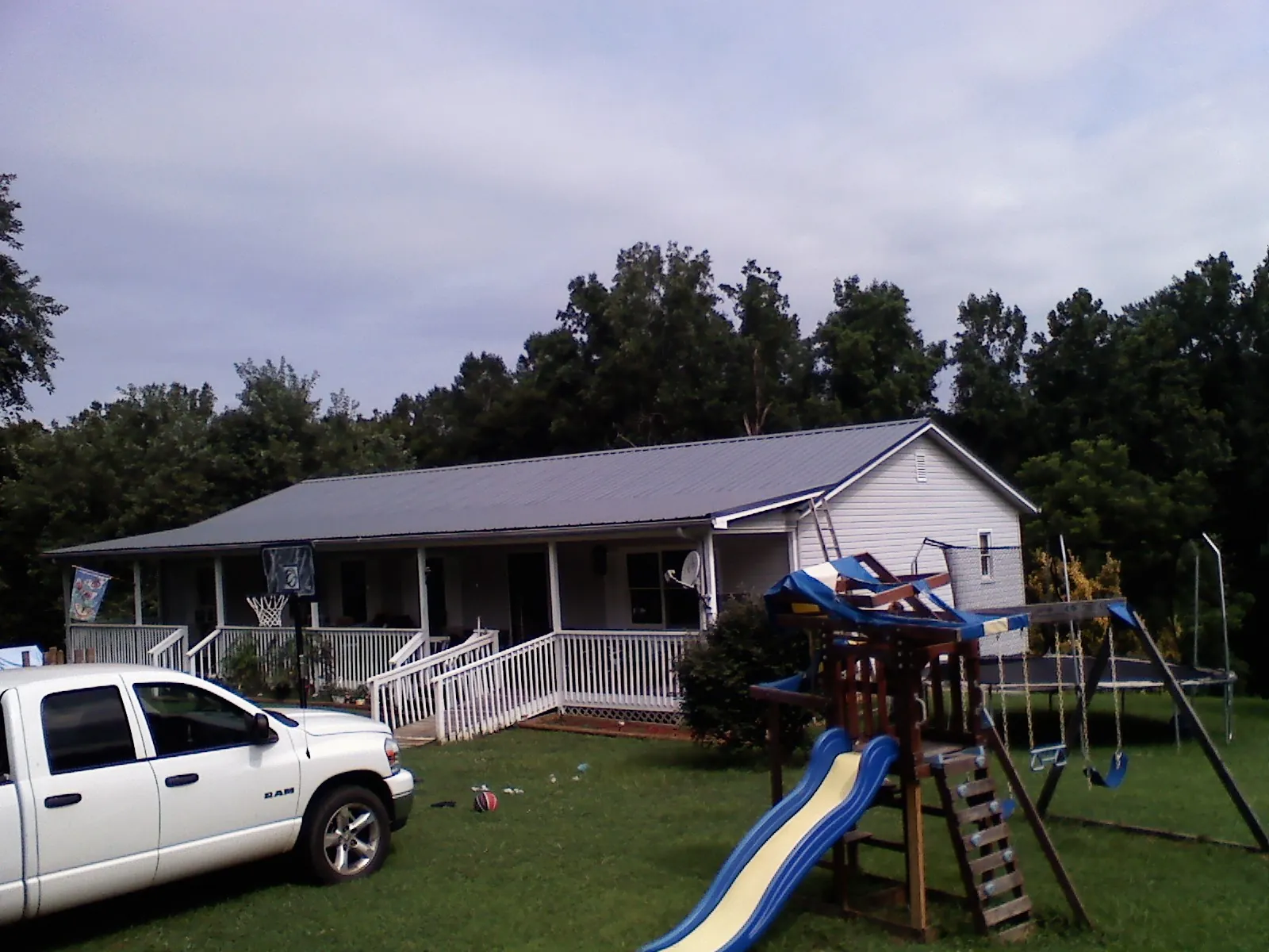 Dark metal roof on a country home with a full length front porch in Campbell